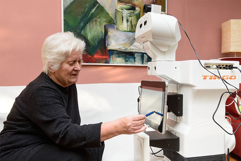TIAGo robot providing assistance to an older woman