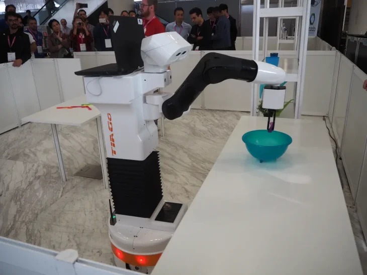 TIAGo robot in a manipulation test grabs an object in a bowl