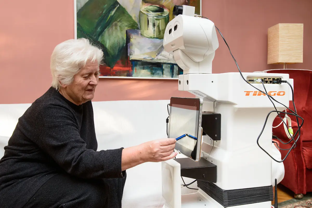 The mobile manipulator TIAGo robot helps an elderly lady during Project EnrichMe