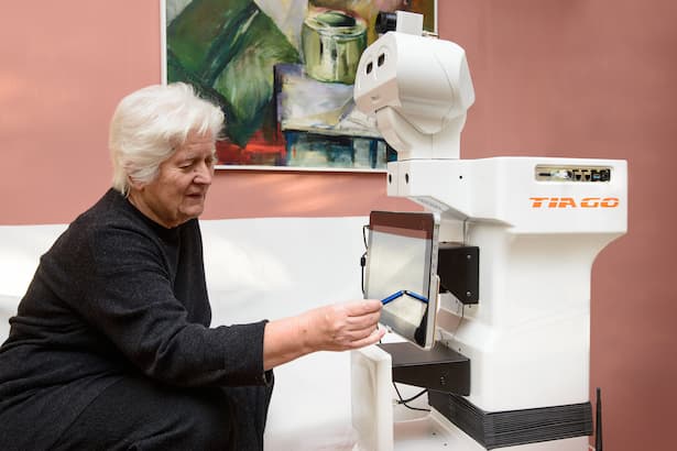 An example of social robotics, as the collaborative robot TIAGo by PAL Robotics assists an elderly woman